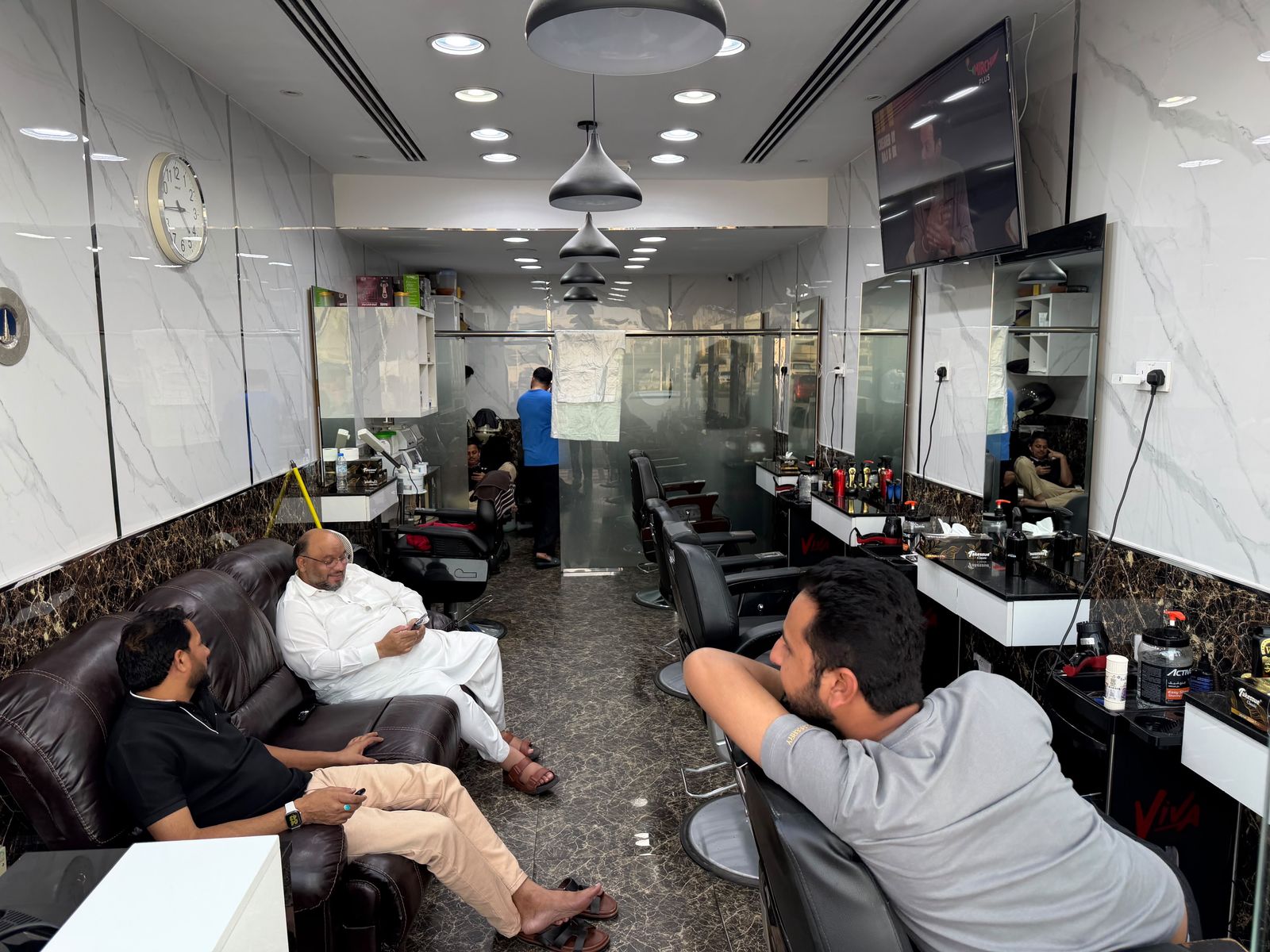Inside Friends Gents Saloon — barber chairs, mirrors and customers waiting in our Dubai salon